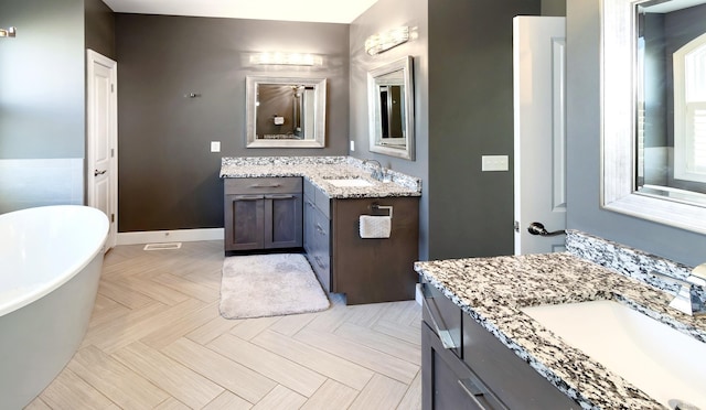 bathroom with vanity, parquet flooring, and a tub