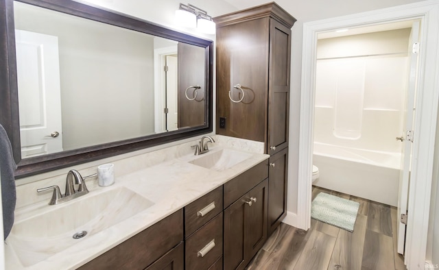 full bathroom featuring vanity, hardwood / wood-style floors, toilet, and shower / bath combination