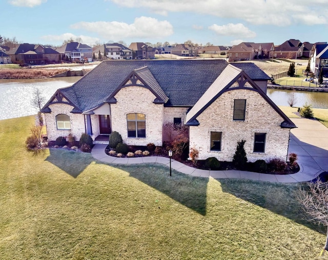 french country home with a water view and a front lawn