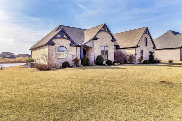 french country style house with central AC and a front lawn