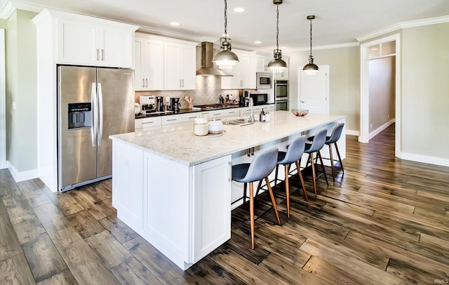 kitchen featuring white cabinetry, stainless steel appliances, a kitchen island with sink, and pendant lighting