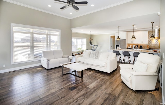 living room with crown molding, dark hardwood / wood-style floors, and ceiling fan