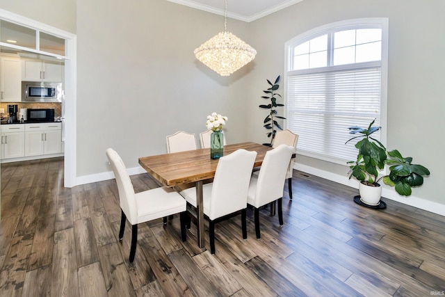 dining space featuring crown molding, dark hardwood / wood-style flooring, and an inviting chandelier