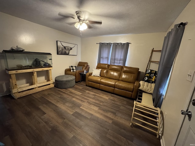 living room featuring ceiling fan, dark hardwood / wood-style floors, and a textured ceiling