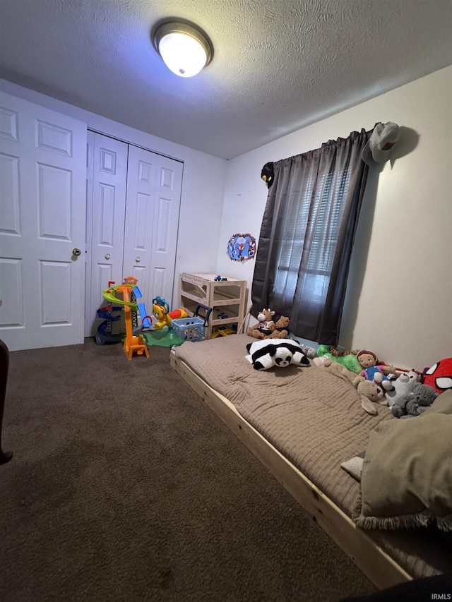 bedroom with a closet, carpet floors, and a textured ceiling