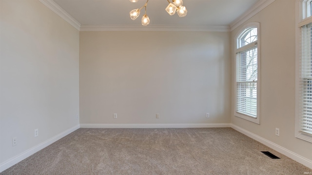 carpeted empty room featuring crown molding and a chandelier