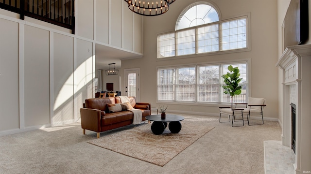 carpeted living room featuring an inviting chandelier and a high ceiling