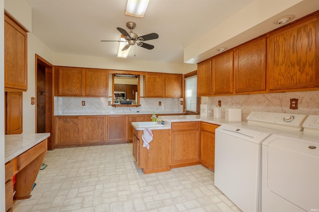 kitchen featuring sink, ceiling fan, washing machine and dryer, tasteful backsplash, and kitchen peninsula