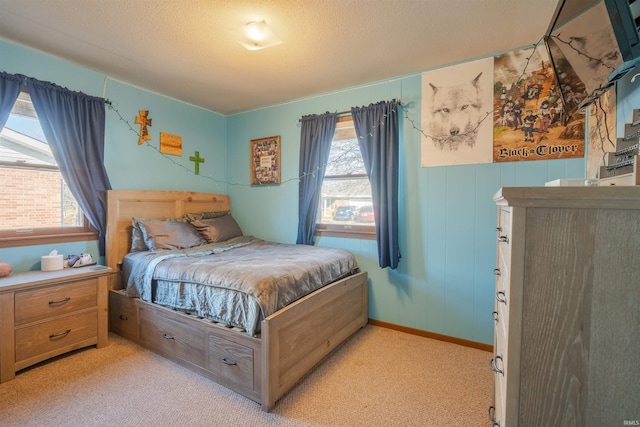 bedroom featuring multiple windows, light colored carpet, and a textured ceiling