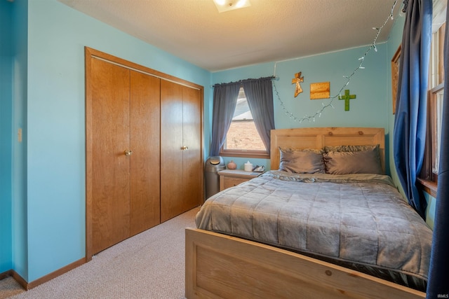 bedroom with light colored carpet, a textured ceiling, and a closet