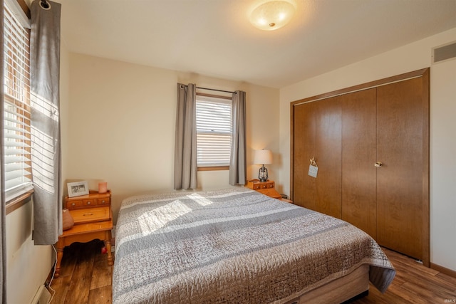 bedroom with dark hardwood / wood-style flooring and a closet