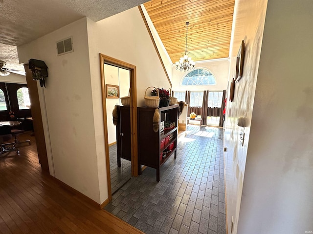 hall featuring french doors, a chandelier, high vaulted ceiling, wooden ceiling, and hardwood / wood-style flooring