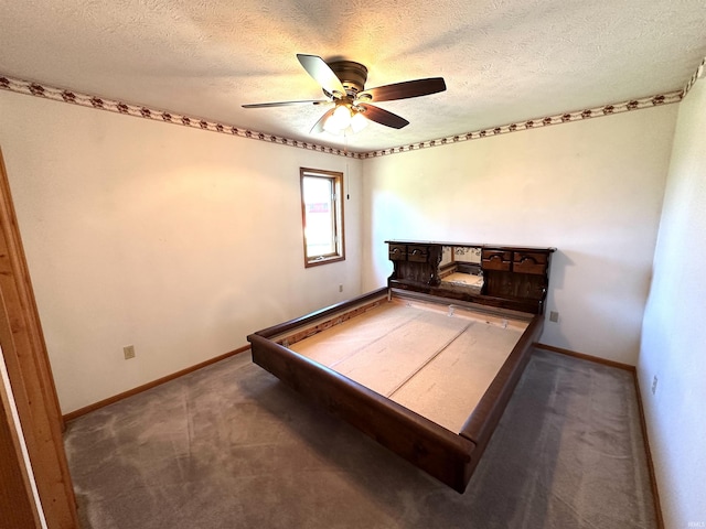 unfurnished bedroom featuring dark colored carpet, ceiling fan, and a textured ceiling