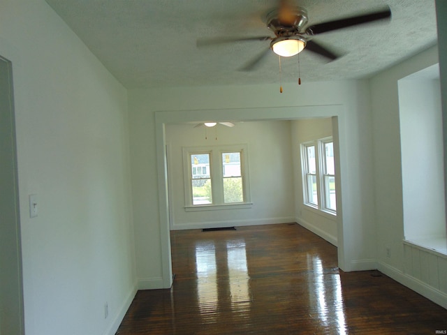 unfurnished room with dark wood-type flooring, ceiling fan, and a textured ceiling