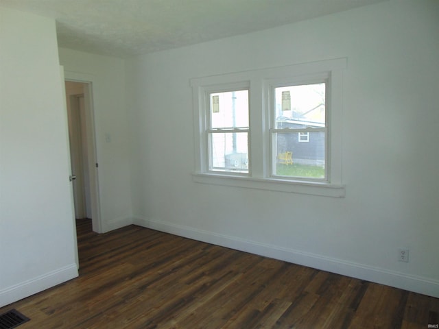 spare room with dark hardwood / wood-style floors