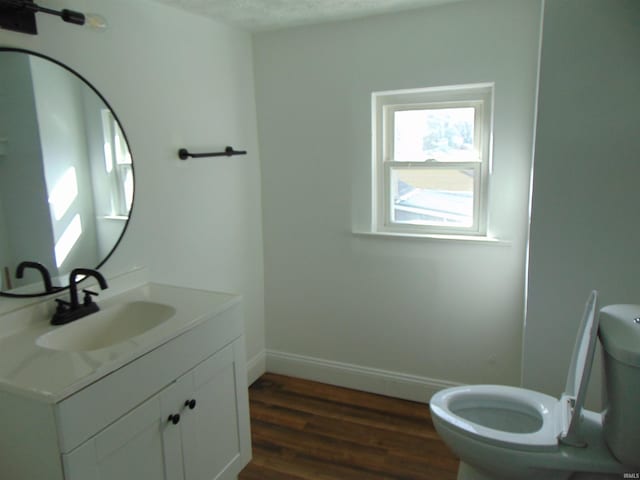 bathroom featuring vanity, toilet, hardwood / wood-style floors, and a textured ceiling