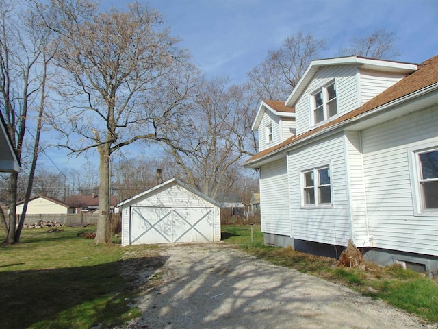 view of side of property featuring a garage, an outbuilding, and a yard