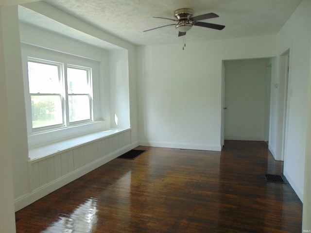 empty room with dark hardwood / wood-style flooring and ceiling fan