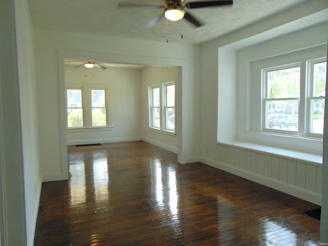 empty room with ceiling fan and dark hardwood / wood-style flooring