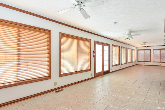 spare room featuring ornamental molding, ceiling fan, and a textured ceiling