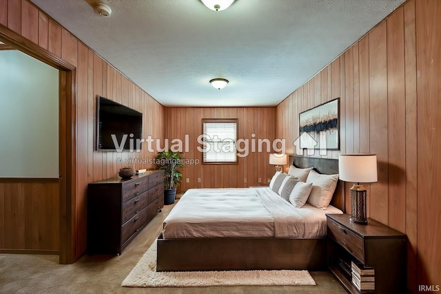 carpeted bedroom featuring wooden walls and a textured ceiling