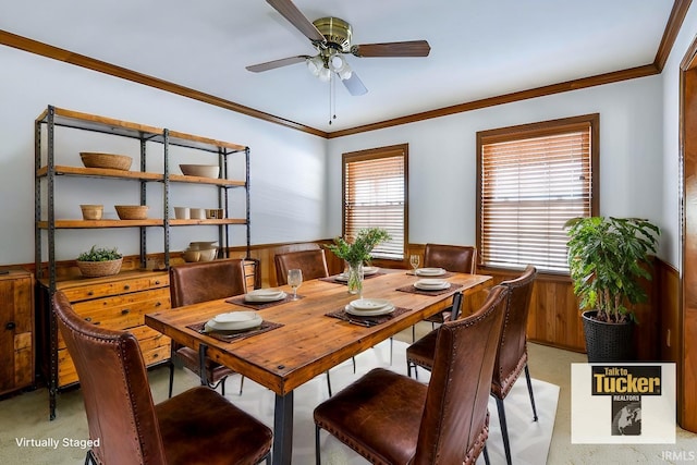 dining area with a wealth of natural light, ornamental molding, wooden walls, and ceiling fan