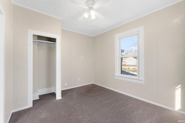 unfurnished bedroom with dark carpet, crown molding, a closet, and ceiling fan