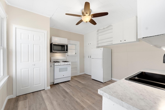 kitchen featuring white cabinetry, sink, ceiling fan, light hardwood / wood-style floors, and white appliances