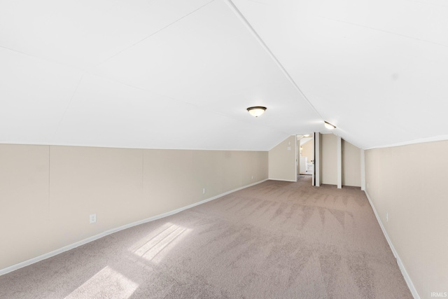 bonus room featuring lofted ceiling and light carpet