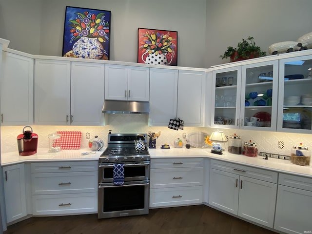 kitchen featuring double oven range, backsplash, and white cabinets