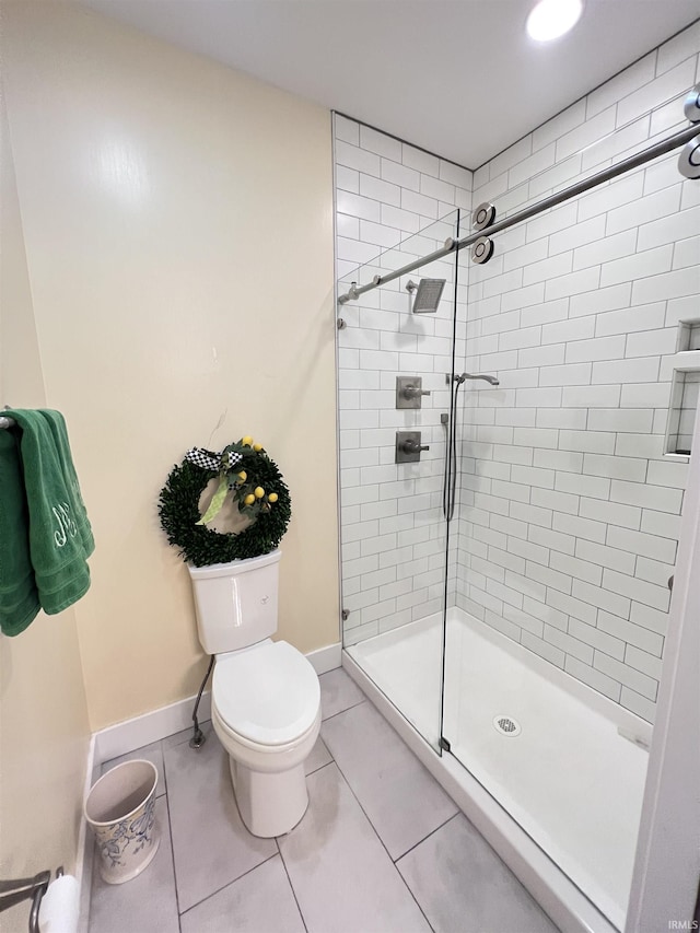 bathroom featuring tile patterned flooring, toilet, and walk in shower