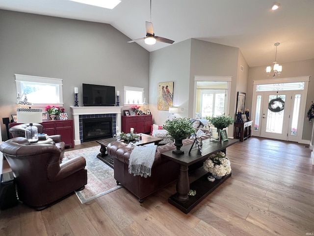 living room featuring a tile fireplace, a healthy amount of sunlight, and light wood-type flooring