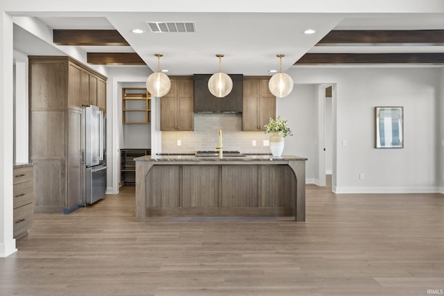 kitchen featuring pendant lighting, backsplash, and light hardwood / wood-style flooring