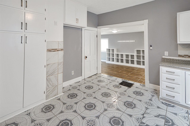 kitchen featuring light tile patterned floors and white cabinets