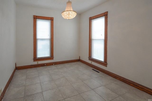 unfurnished room with a chandelier