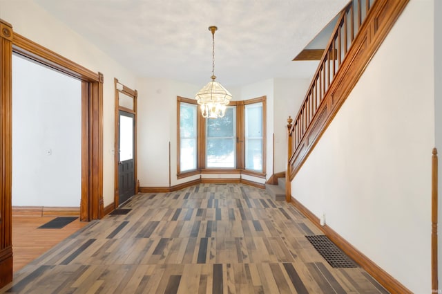 entryway with dark hardwood / wood-style flooring and a chandelier