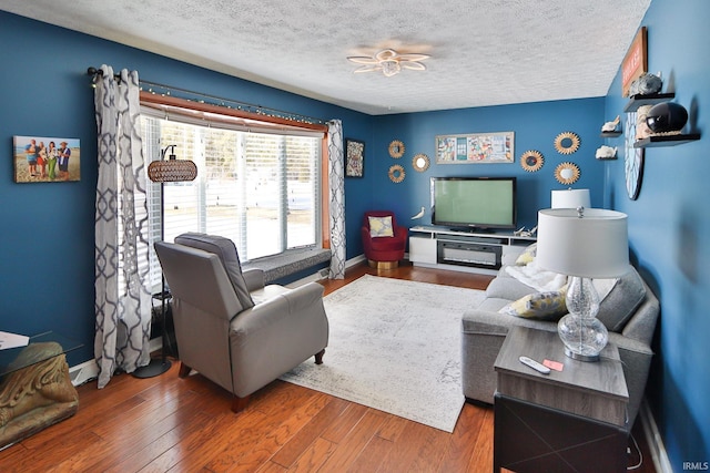 living room with wood-type flooring and a textured ceiling