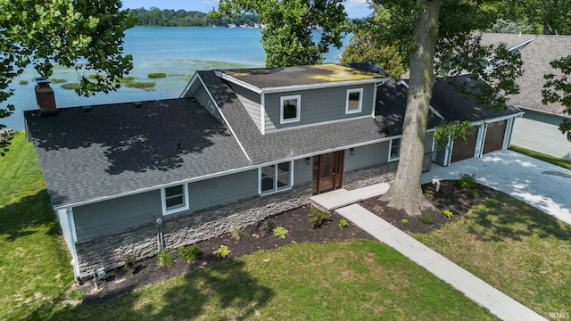 view of front of home with a water view and a front lawn