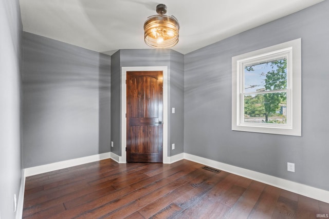 spare room featuring dark wood-type flooring