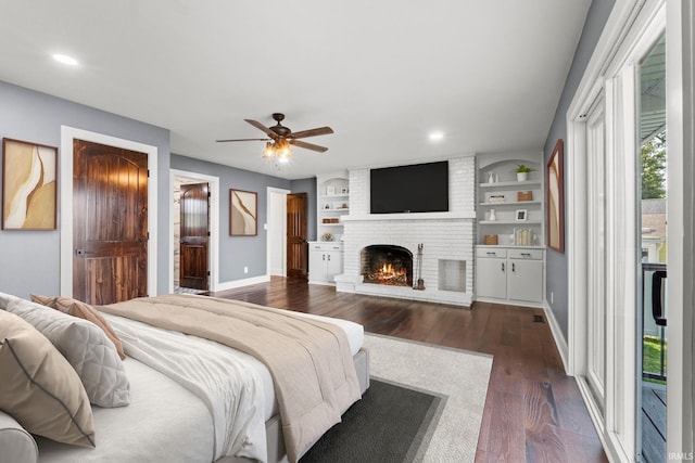 bedroom with dark hardwood / wood-style flooring, access to outside, ceiling fan, and a fireplace