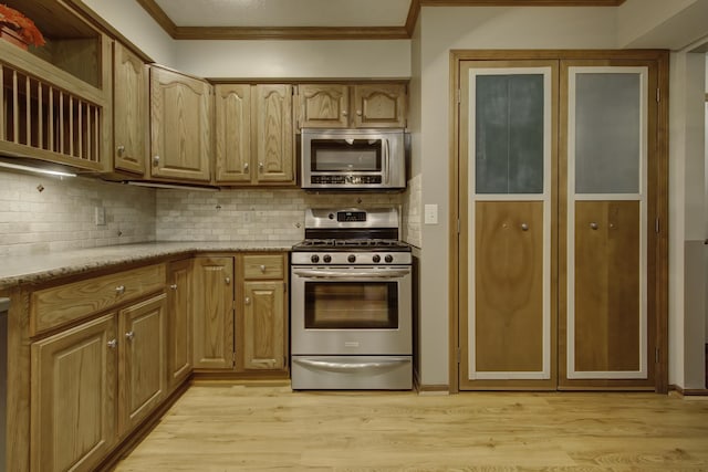 kitchen featuring tasteful backsplash, ornamental molding, stainless steel appliances, and light hardwood / wood-style flooring