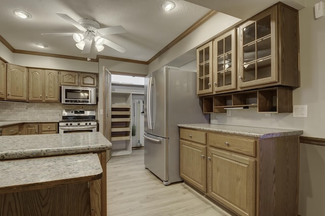 kitchen with appliances with stainless steel finishes, backsplash, ceiling fan, light hardwood / wood-style floors, and crown molding