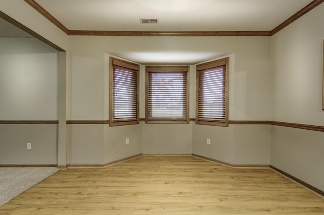 empty room with ornamental molding and light wood-type flooring