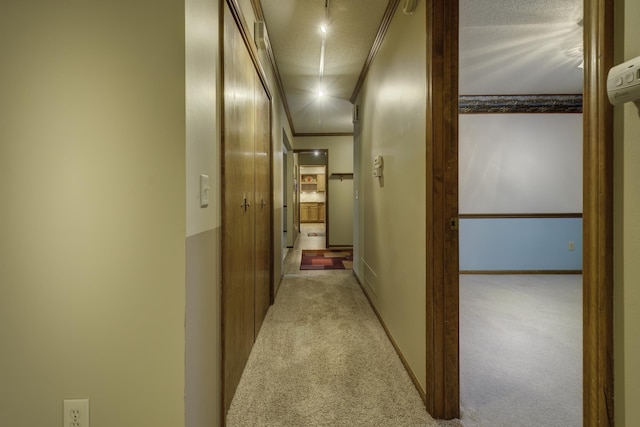 hallway featuring crown molding, light carpet, and a textured ceiling