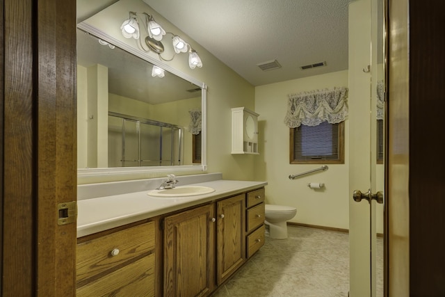 bathroom featuring a shower with shower door, tile patterned flooring, vanity, toilet, and a textured ceiling