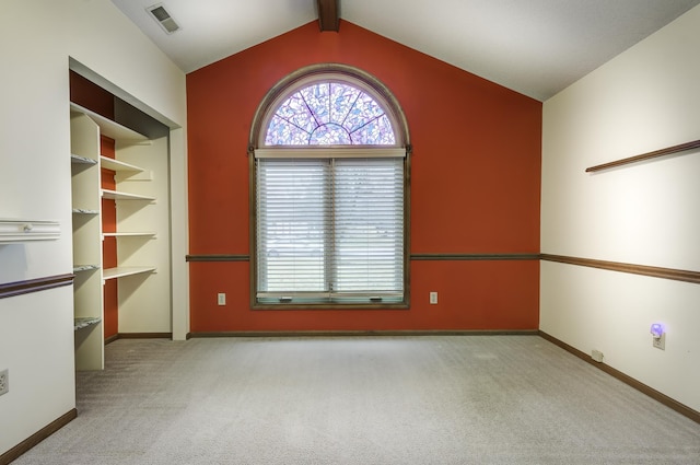 unfurnished room with lofted ceiling with beams and light carpet