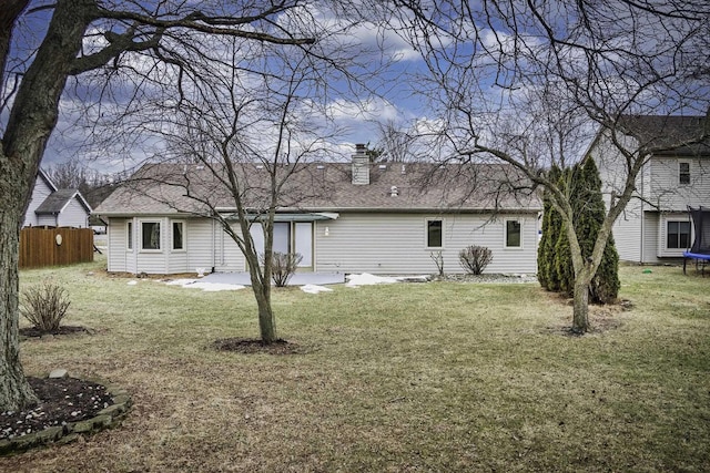 back of house featuring a trampoline, a yard, and a patio