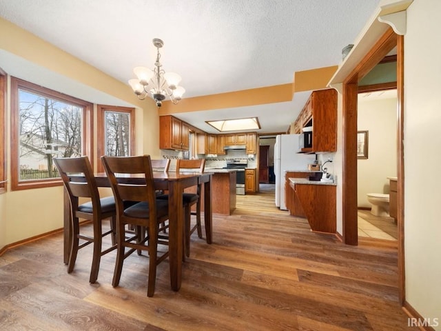 dining area featuring an inviting chandelier and light hardwood / wood-style floors