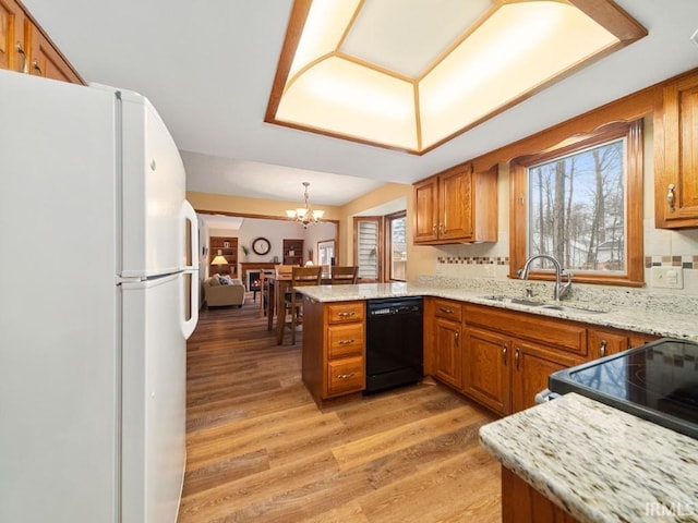 kitchen featuring sink, black dishwasher, decorative light fixtures, kitchen peninsula, and white fridge