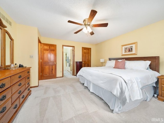 bedroom with light carpet, ceiling fan, and ensuite bath